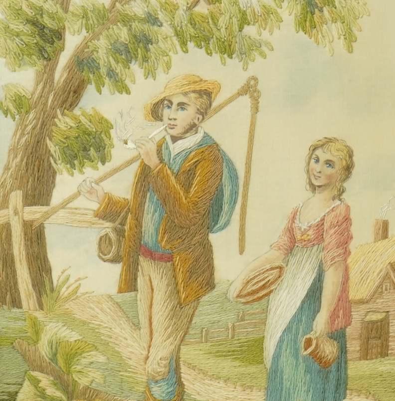 An early 20th silk embroidery of a boy and a girl in a country landscape by a tree and cottage. Worked in stem stitch with painted faces hands and background. Mounted with Verre Eglomise glass and a gilt rectangular fram
